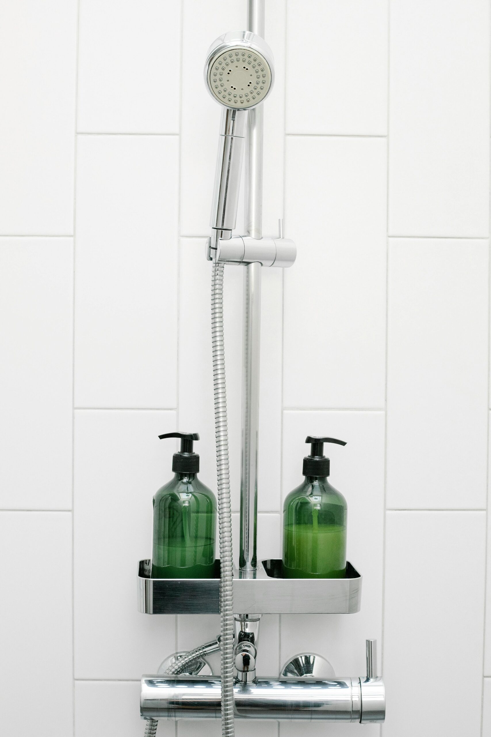 shower storage shelf near a handheld showerhead with bottles