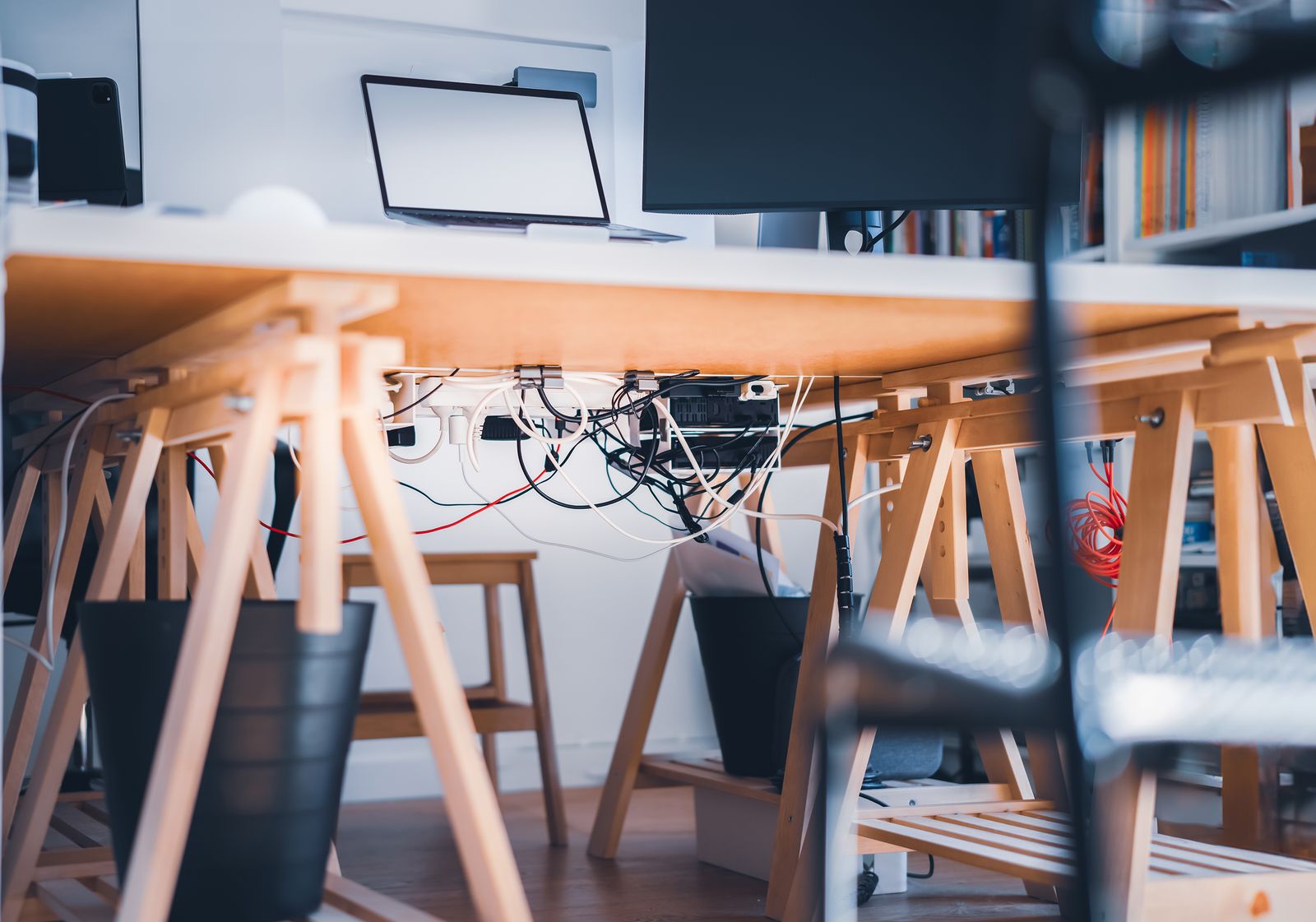 Laptop and external monitor setup with connected cables under a desk