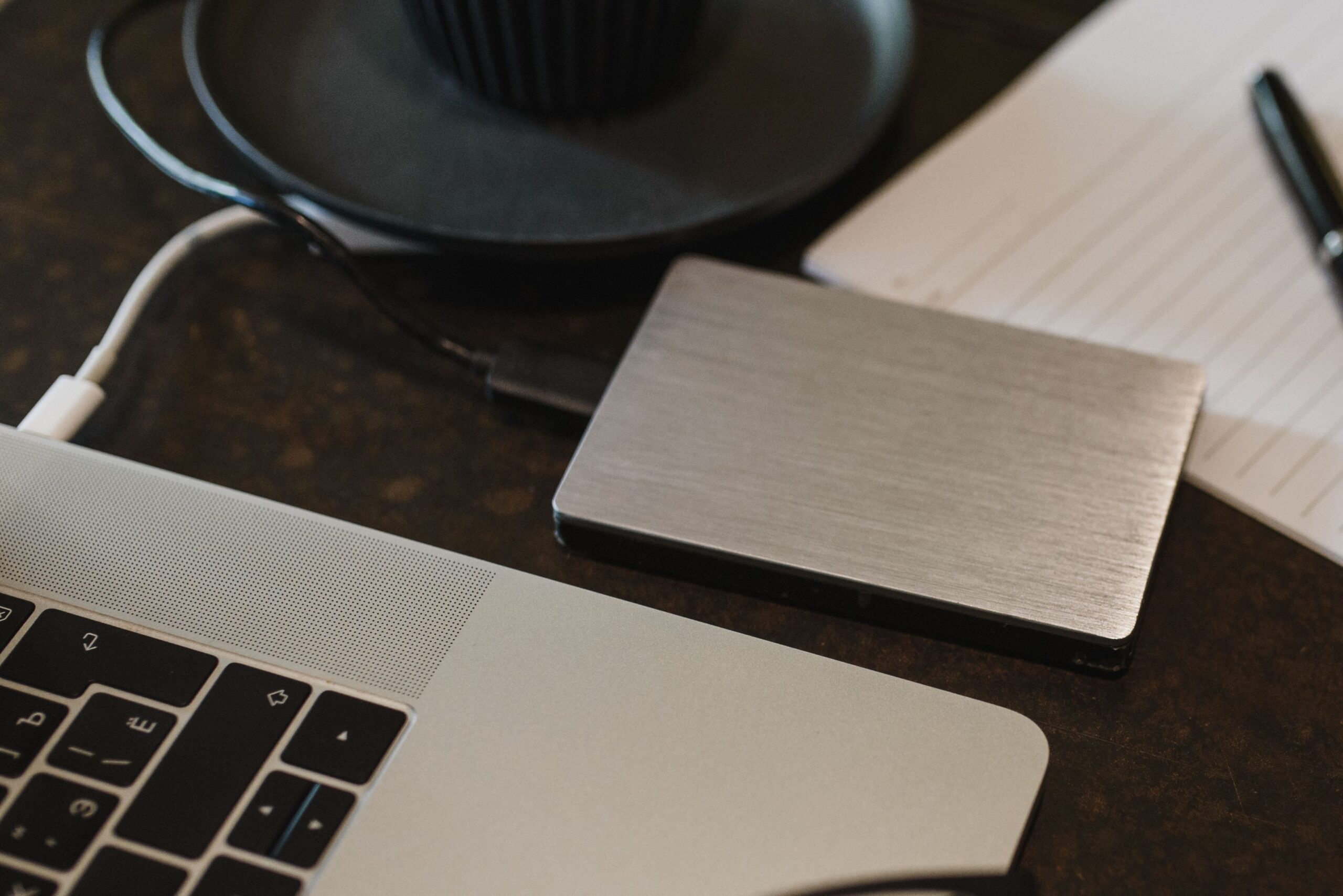 Portable external storage drive connected to a laptop by USB cable