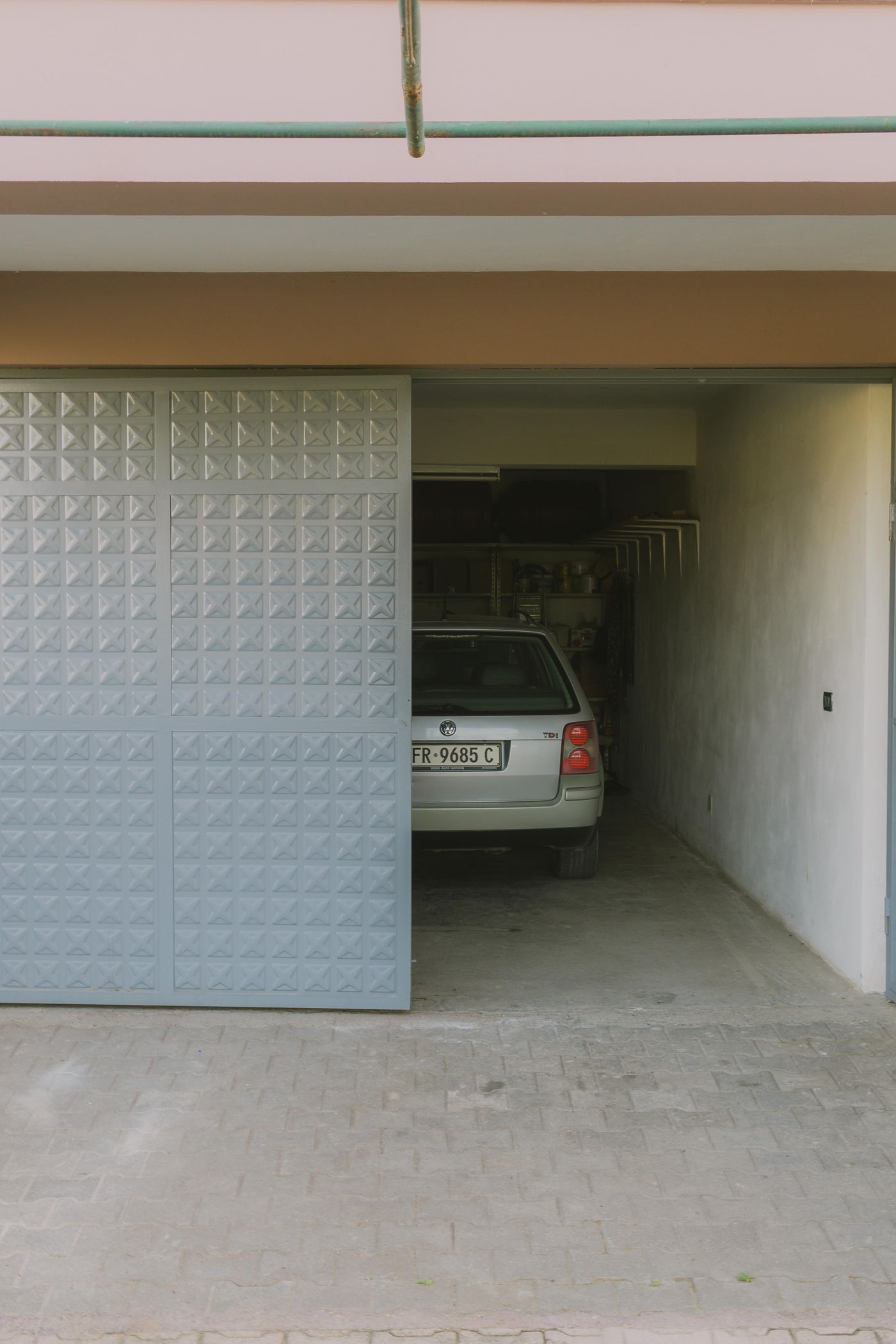 Residential garage door and driveway illustrating smart garage controller installation context